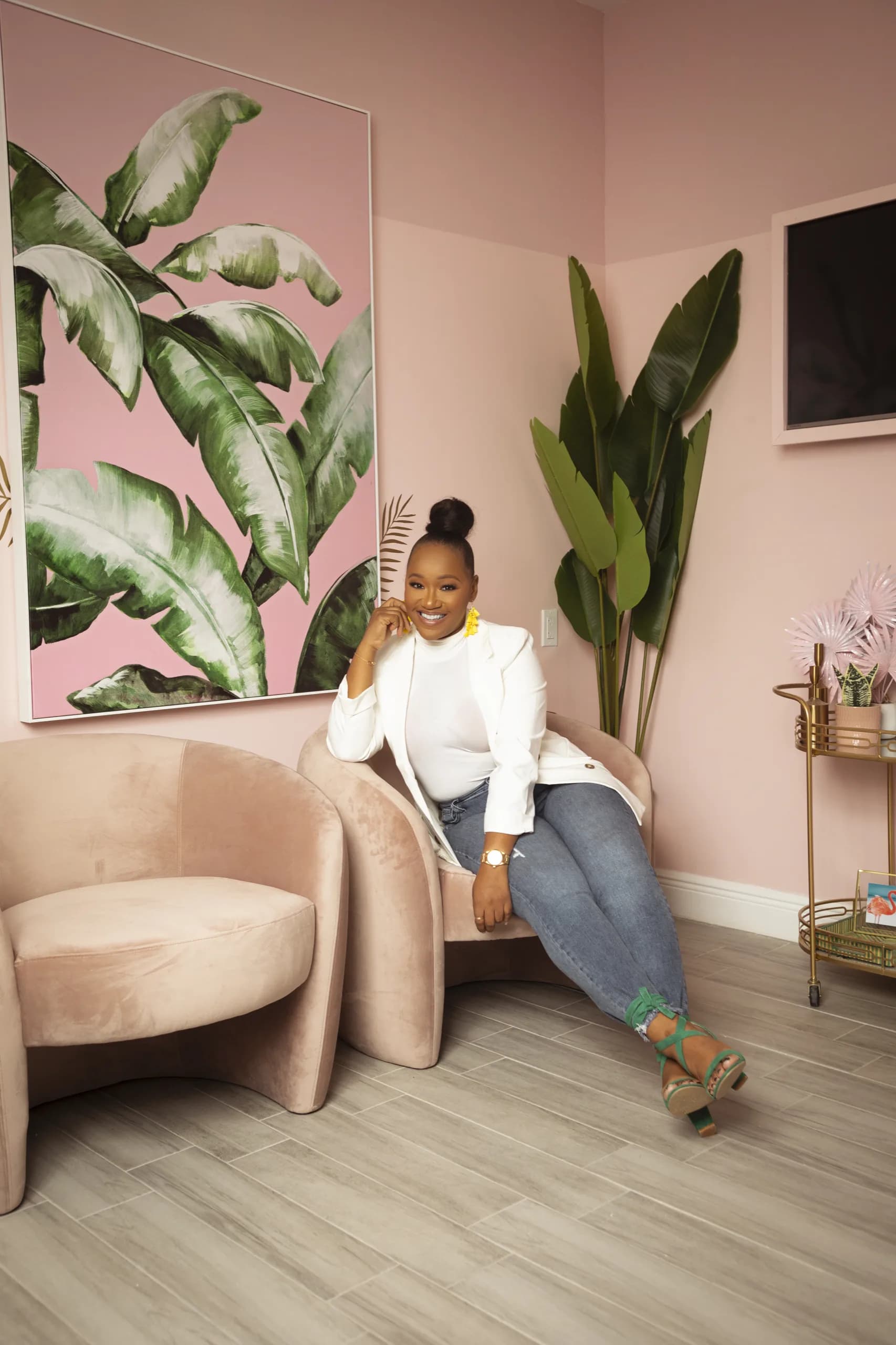 Petra Haven seated in a pink lounge chair, smiling to camera